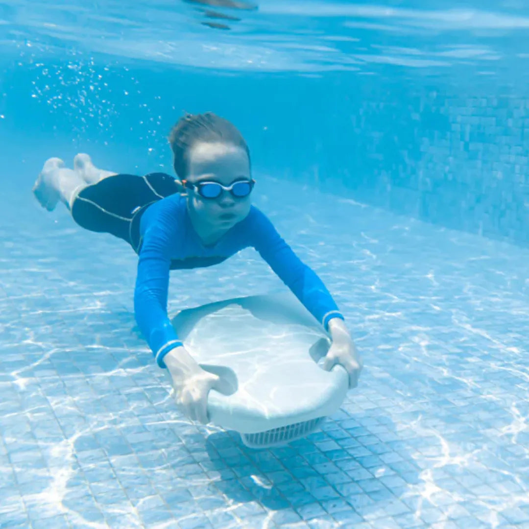 Izdelek na sliki je električna plavalna deska, model "ASIWO Mako". Na sliki je otrok, ki plava pod vodo in drži desko, oblečen v modro majico in plavalne očala. V ozadju je vidna modra voda bazena, kar nakazuje, da se izdelek uporablja v vodnem okolju.