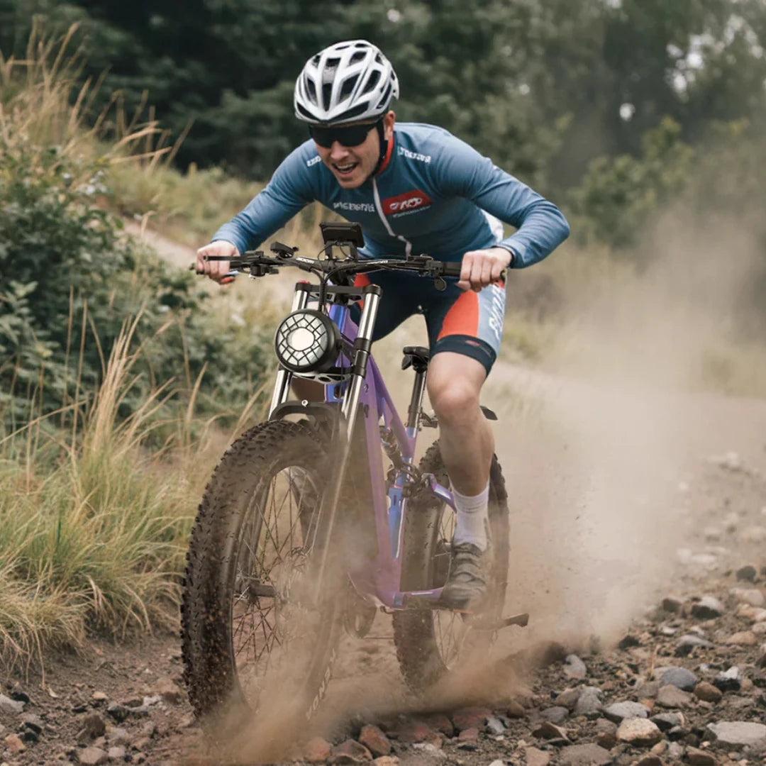 Electric Bike Duotts E26, rider on rough terrain, purple frame, robust tires, front light, outdoor action.