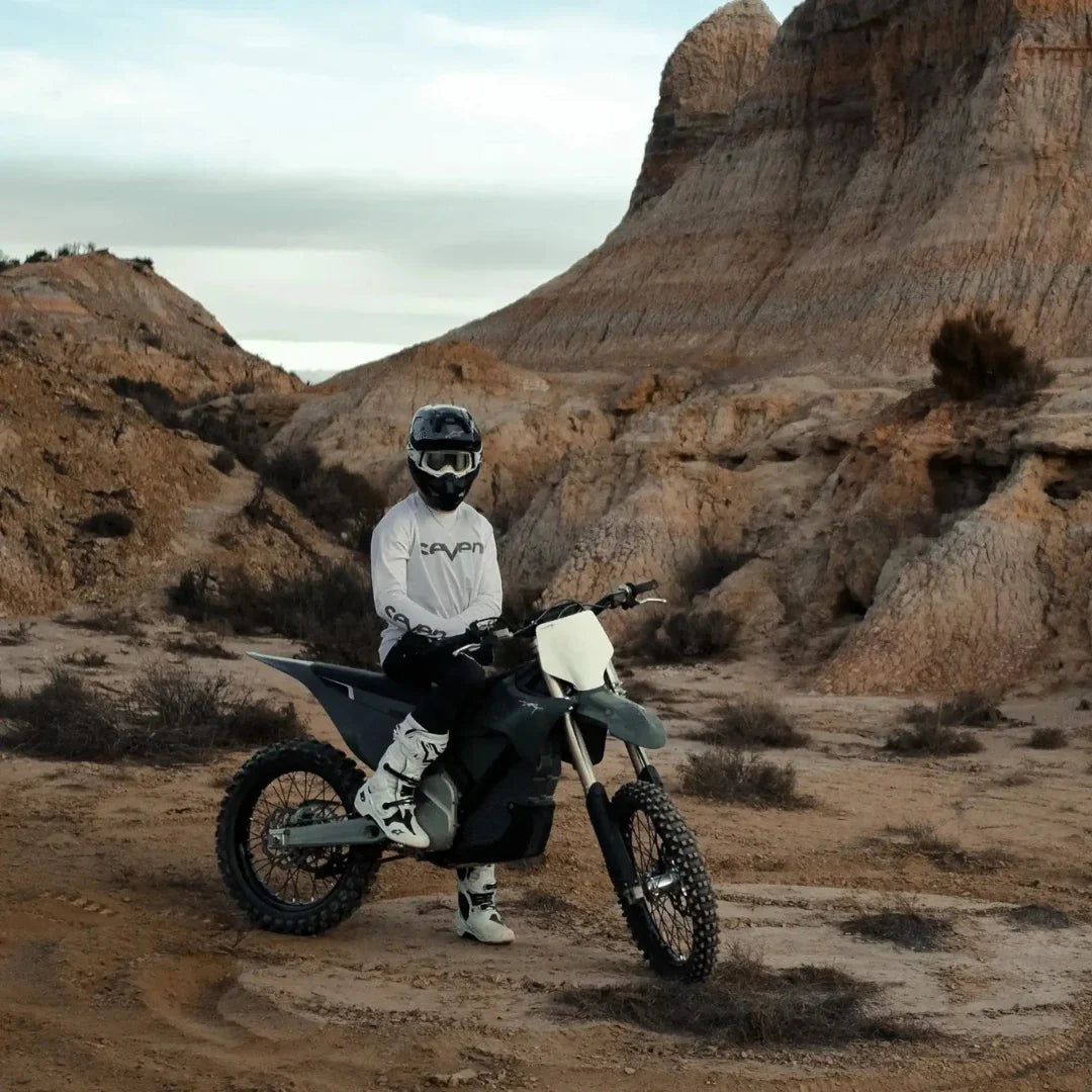 Voznik električnega motokros kolesa Stark Varg v razgibani, skalnati pokrajini.