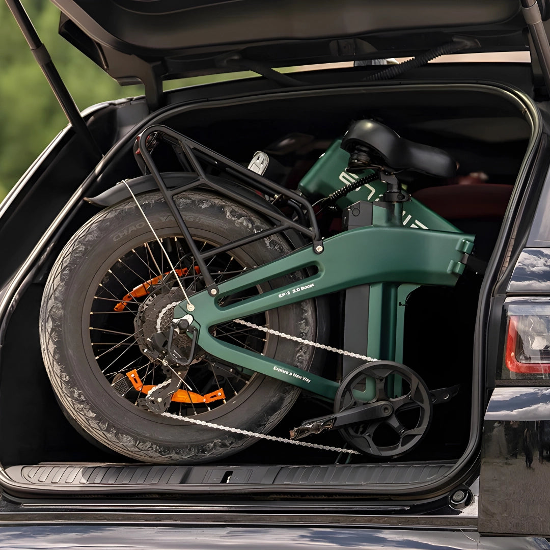Na sliki je električno kolo znamke Engwe, model EP-2 3.0 Boost. Kolo je zloženo in shranjeno v prtljažniku avtomobila, kar kaže na njegovo prenosljivost. Vidni so veliki kolesi s profiliranimi pnevmatikami ter del okvirja in sedeža kolesa.
