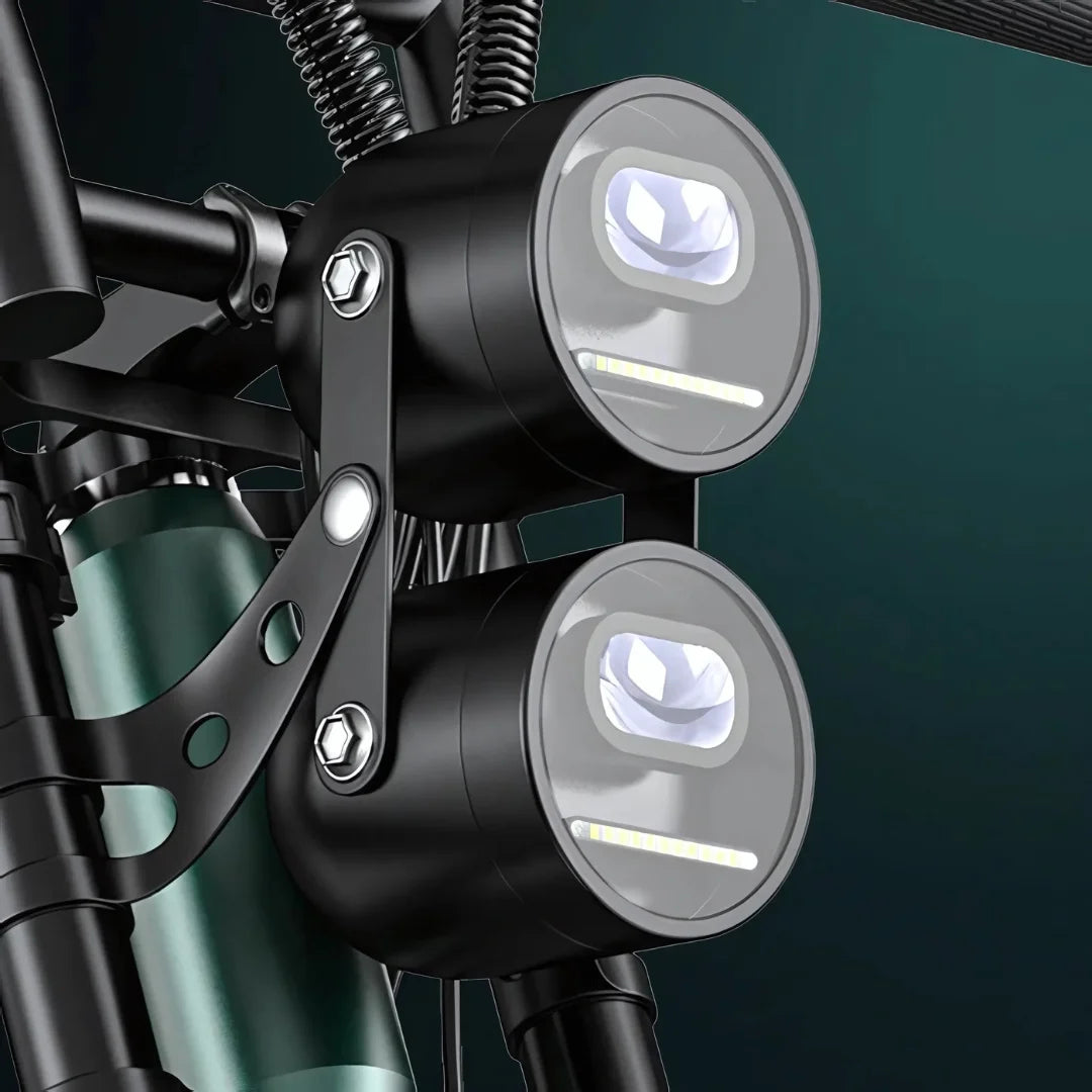 Na sliki je prikaz električnega kolesa, model Engwe M20. Vidni so sprednji svetili, ki sta nameščeni na okvirju kolesa. Svetili sta okrogli in imata sodoben dizajn, kar nakazuje na funkcionalnost in estetsko privlačnost izdelka. Oba svetila sta pritrjena z nosilcem, kar zagotavlja stabilnost in varnost med vožnjo.