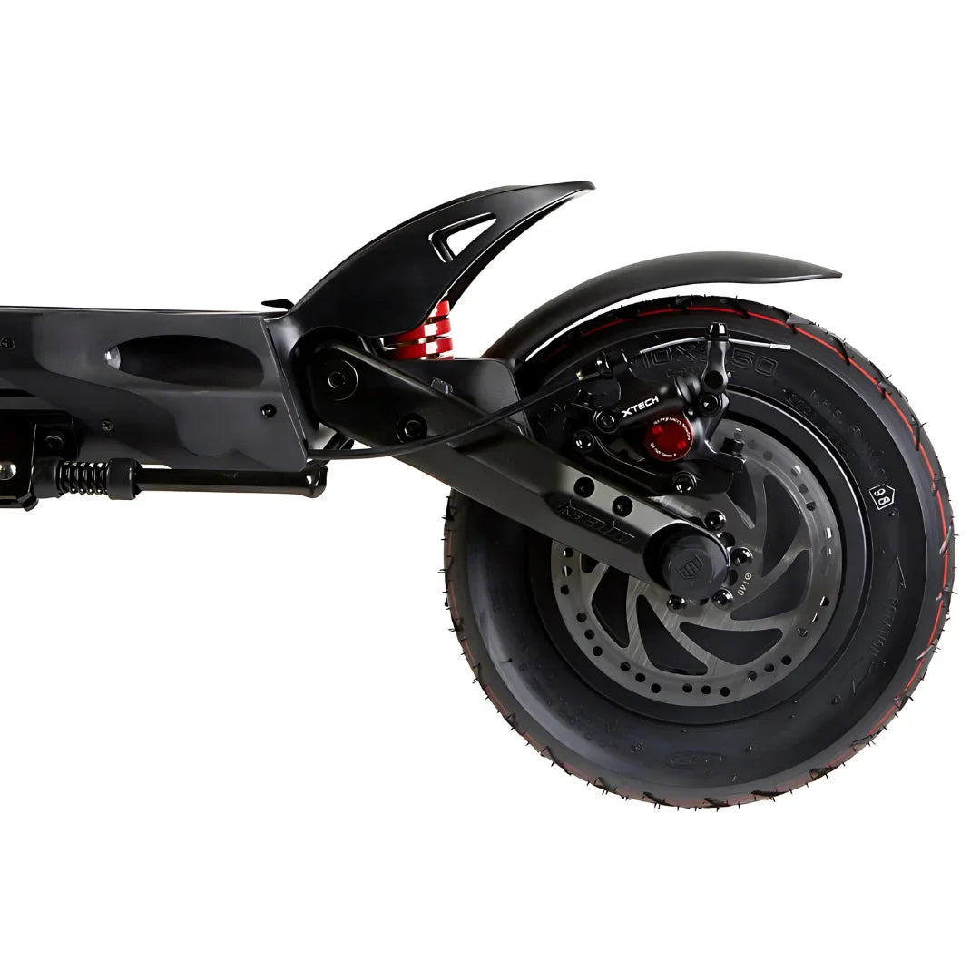 Izdelek na sliki je električni skiro, model Kaabo Mantis 10 Plus. Na sliki je prikazan zadnji del skiroja, vključno z zadnjim kolesom, vzmetenjem in zavorami. Kolo ima široko pnevmatiko z izrazitim profilom, kar nakazuje na dobro oprijemljivost, medtem ko je vzmetenje zasnovano za udobno vožnjo po različnih površinah.