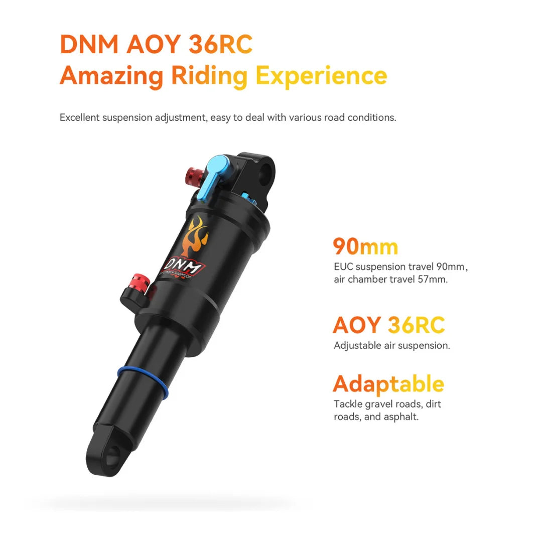 Na sliki je prikazan amortizer DNM AOY 36RC, ki je zasnovan za električne monocikle. Amortizer omogoča prilagodljivo zračno vzmetenje s potovanjem 90 mm, kar zagotavlja udobno vožnjo po različnih terenih, vključno z makadamom in asfaltom. Vidne so tudi oznake in specifikacije, ki poudarjajo njegove lastnosti in prednosti.