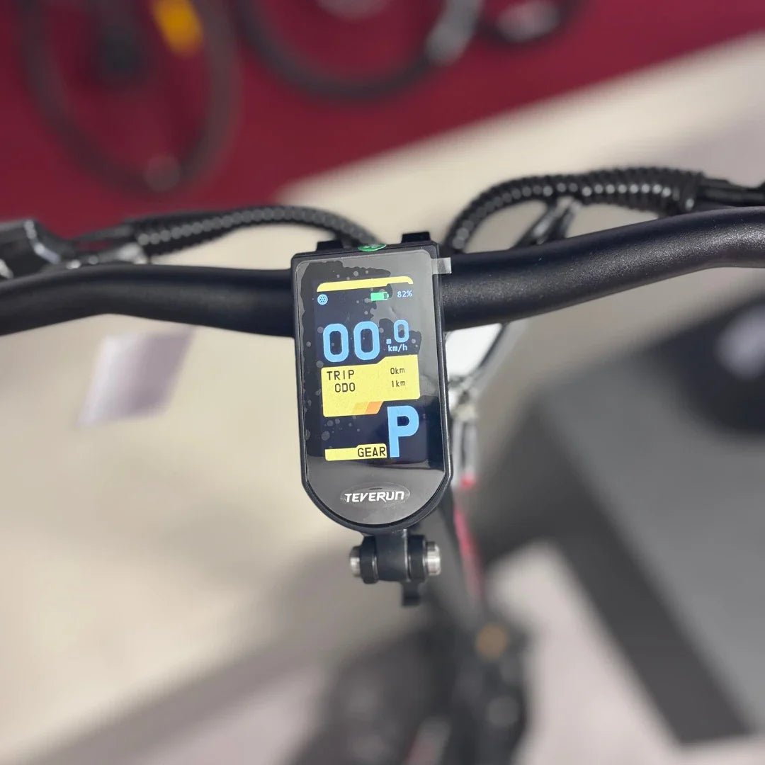 Izdelek na sliki je električni skiro, model Teverun Fighter Mini Pro 2025. Na sliki je prikazan nadzorni zaslon skiroja, ki prikazuje hitrost, skupno prevoženo razdaljo ter stanje baterije. Zaslon je nameščen na krmilu in omogoča enostavno spremljanje podatkov med vožnjo.