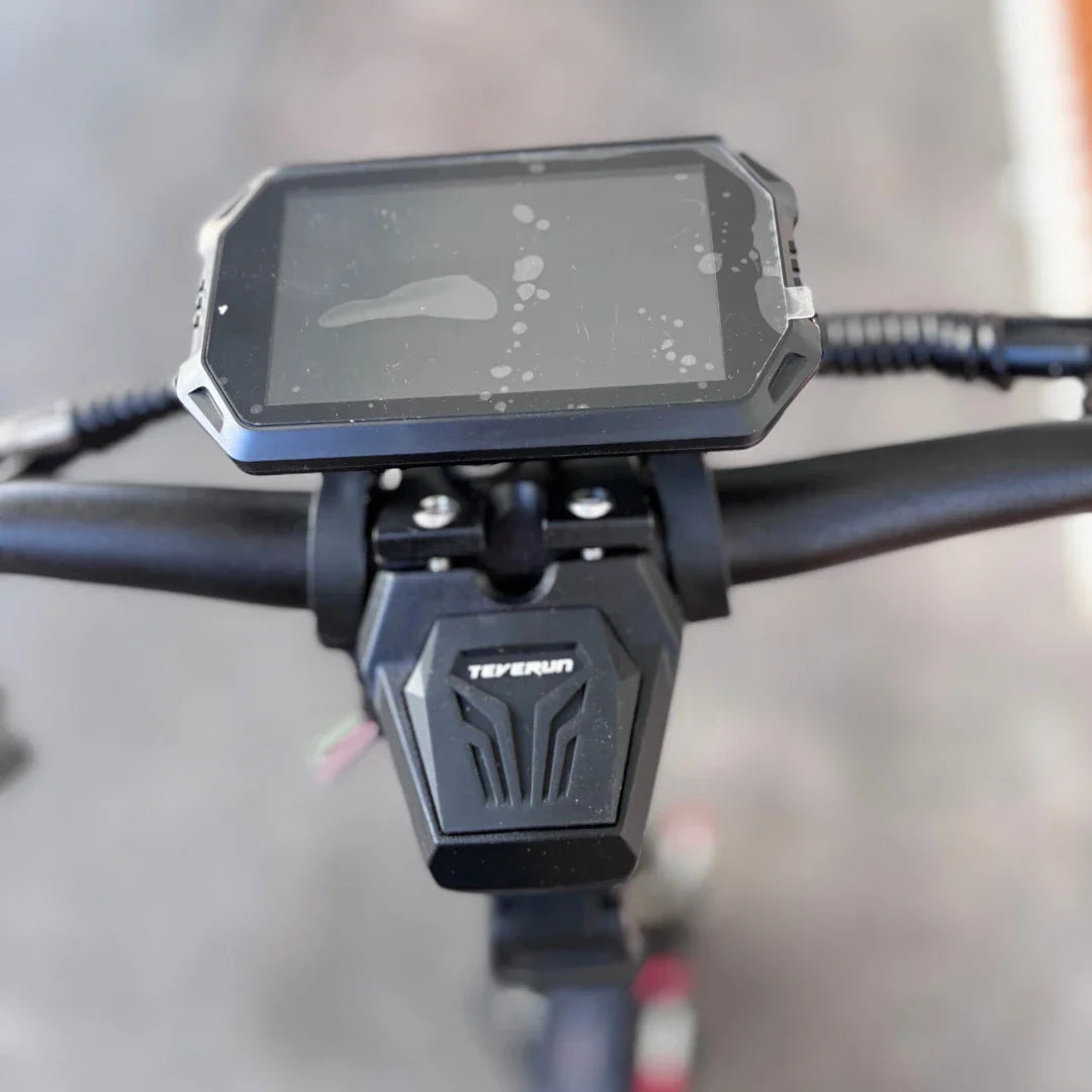 Izdelek na sliki je električni skiro znamke Teverun, model Fighter Supreme 7260 Ultra. Na sliki je prikazano krmilo skiroja z digitalnim zaslonom, ki prikazuje informacije o vožnji. Zaslon je zaščiten z robom in je nekoliko umazan, kar kaže na uporabo. Pod zaslonom je vidna tudi oznaka znamke Teverun.