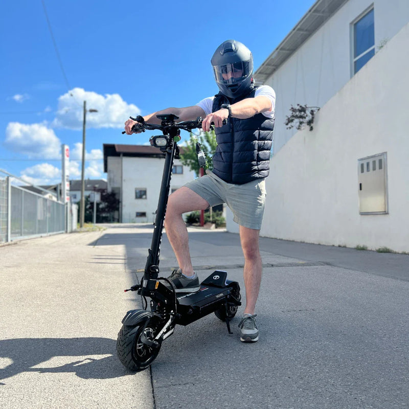 Electric Scooter Teverun Fighter Supreme 7260 Ultra, sleek design with robust tires, man wearing a helmet, urban setting.