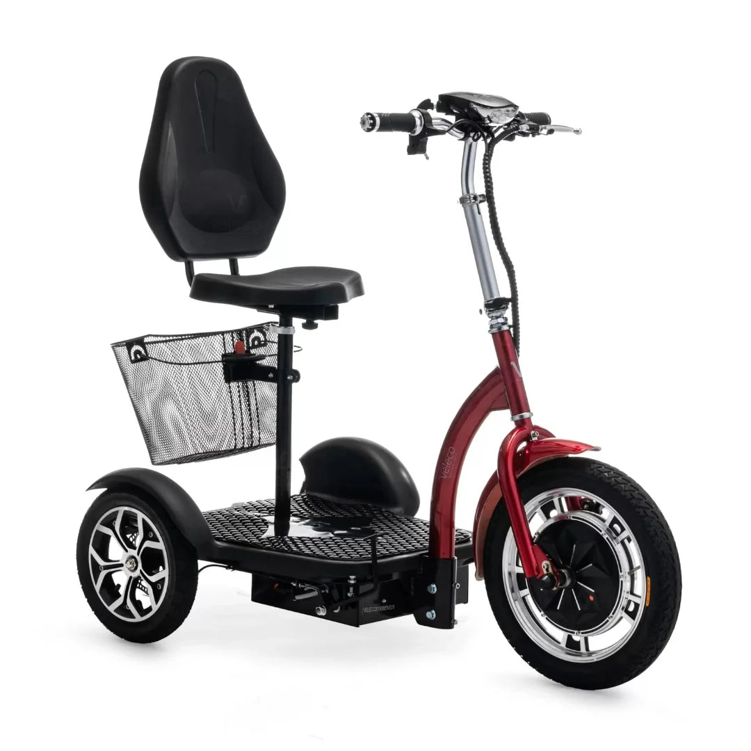 Izdelek na sliki je električni mobilni voziček, model Veleco ZT16. Ima udoben sedež in široko platformo za stojanje, kar omogoča enostavno uporabo. Na zadnji strani je mrežna košara za shranjevanje, spredaj pa so vidne velike kolesa, kar zagotavlja stabilnost in udobno vožnjo. Barva vozička je rdeča, kar mu daje privlačen videz.