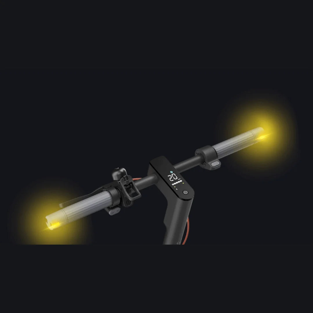 Na sliki je električni skiro znamke Xiaomi, model 5 Pro. Vidni so krmili s svetlobnimi indikatorji na obeh straneh, kar povečuje vidnost med vožnjo. Na sredini krmila je tudi digitalni zaslon, ki prikazuje pomembne informacije, kot je hitrost. Celoten dizajn je eleganten in sodoben, kar je značilno za to znamko.