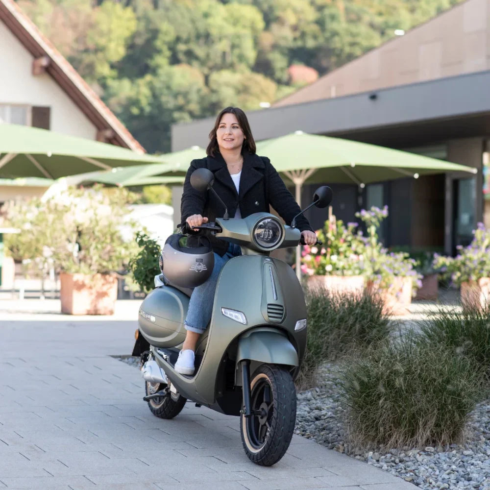 Ženska se vozi z električnim skuterjem Efo Et3000 v slikovitem okolju na prostem.