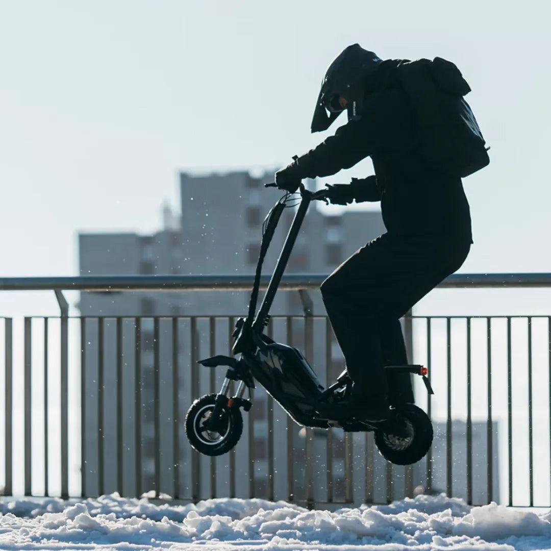 Oseba se vozi z električnim skirojem Acer Predator Extreme Pes017 po zasneženem terenu.