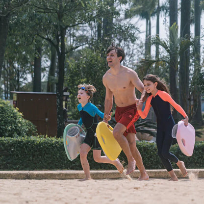 Izdelek na sliki je električni plavalni deska, model "Mako" znamke Asiwo. Na sliki so trije otroci in odrasla oseba, ki se veselijo na plaži, oblečeni v kopalne obleke. Vsak drži električno desko, ki je na voljo v različnih barvah. V ozadju so drevesa in naravna okolica, kar ustvarja sproščeno vzdušje.
