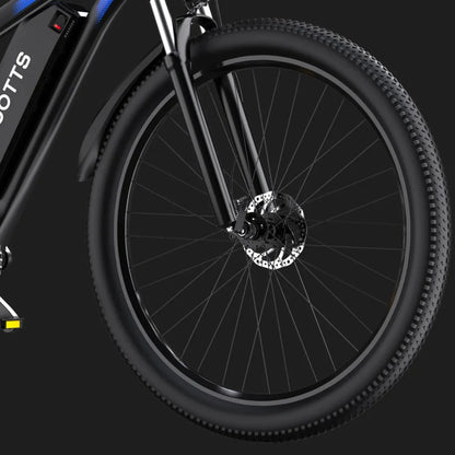 Izdelek na sliki je električno kolo znamke Duotts, model C29. Na sliki je vidna sprednja kolesa s širokimi gumami in disk zavornim sistemom, kar kaže na robustno zasnovo, primerno za različne terene. Kolo ima tudi elegantno črno barvo in sodoben dizajn.