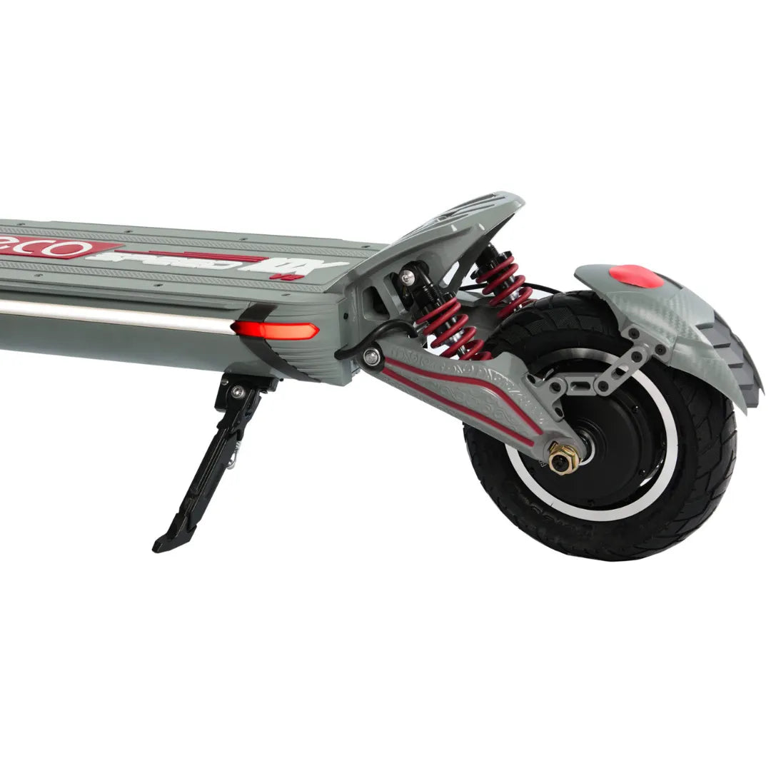 Izdelek je električni skiro, model Eco Speed 10X V2. Na sliki je prikazan del skiroja, ki vključuje široko kolo s solidnim profilom in vzmetenje, kar omogoča udobno vožnjo. Vidna je tudi platforma za stojišče ter nosilec za stabilnost. Barvna kombinacija vključuje sivo in rdeče detajle, kar daje skiroju športen videz.