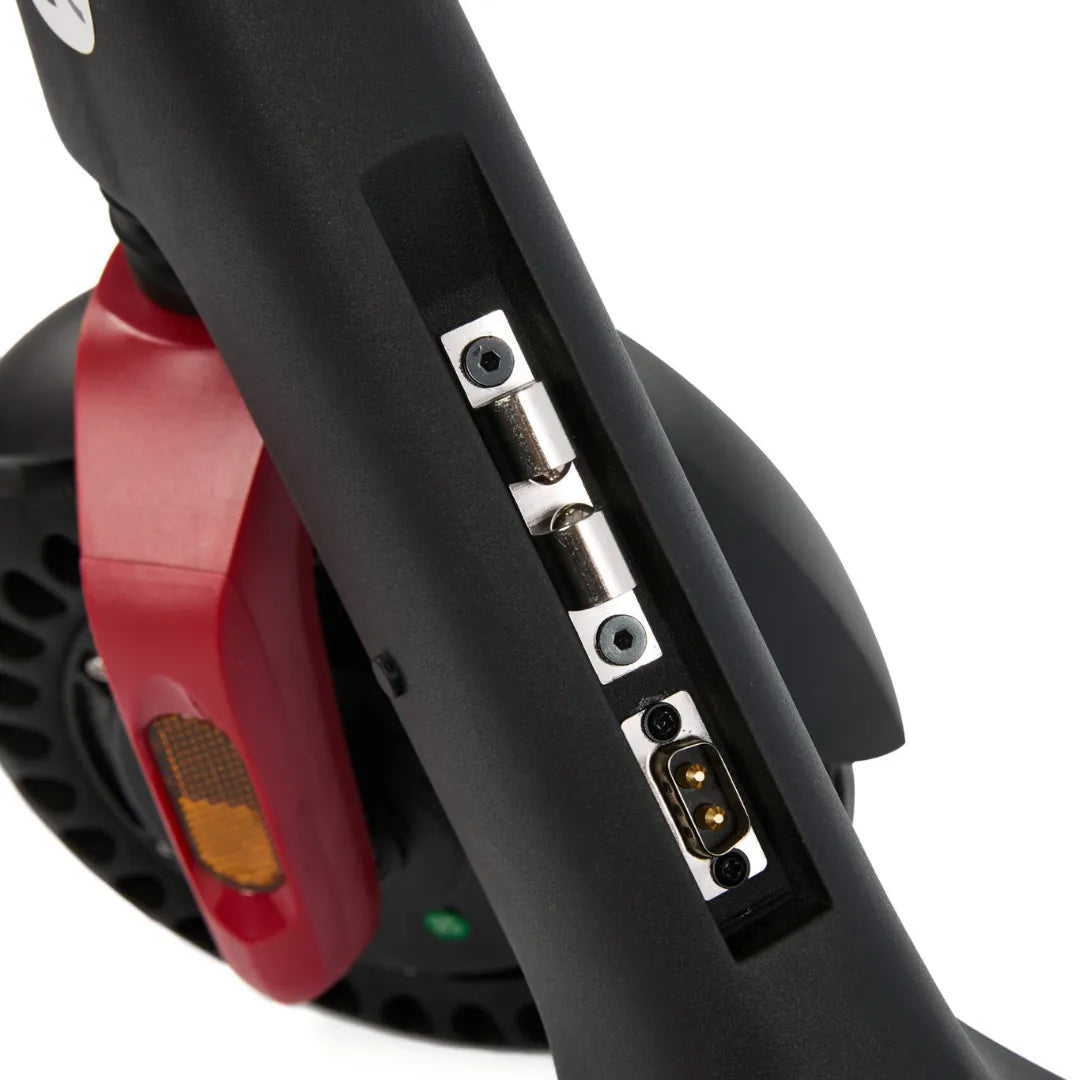 Izdelek je električni skiro, model Eco Speed Mini. Na sliki je prikazan del skiroja, kjer so vidne povezave za polnjenje in mehanizem za zlaganje. Ohišje je črne barve, z rdečim gumbom in odsevniki, kar nakazuje na funkcionalnost in varnost pri uporabi.