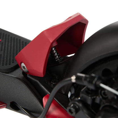 Izdelek je električni skiro, model Eco Speed Mini. Na sliki je vidna podrobnost mehanizma skiroja, kjer je rdeča zaščita, ki pokriva del vzmetenja. Vidni so tudi deli, ki omogočajo delovanje kolesa, ter črni kabli, ki so del električnega sistema. Celoten dizajn je minimalističen in funkcionalen.