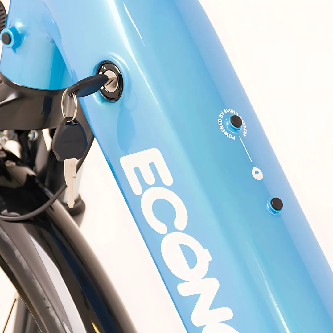 Izdelek je električno kolo, model Econo Mare City EEC4LK. Na sliki je vidna ključavnica za vžig, ki je nameščena na okvirju kolesa, ter del oznake znamke "Econo". Barva okvirja je svetlo modra, kar daje kolesu sodoben videz. Vidni so tudi gumbi za vklop in indikator delovanja.