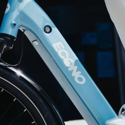 Izdelek je električno kolo, znamke Econo, model Mare City EEC4LK. Na sliki je vidna okvirna struktura kolesa v svetlo modri barvi, s poudarjenim logotipom Econo. Prav tako je opazna detajlna obdelava okvirja ter vtičnica za polnjenje baterije. Kolo ima tudi široke pnevmatike, kar nakazuje na udobno vožnjo po mestnih površinah.