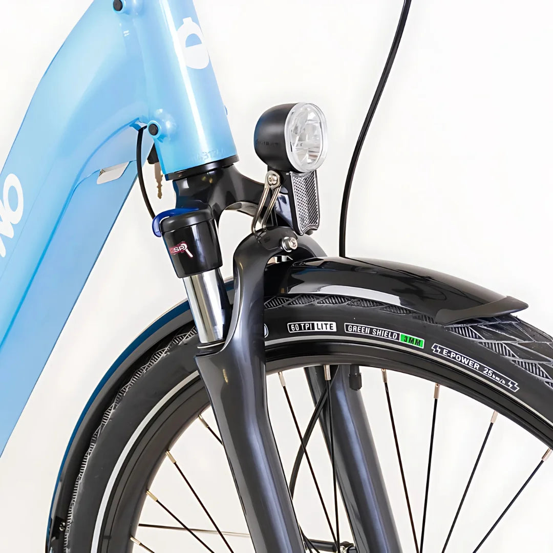 Izdelek je električno kolo znamke Econo, model Mare City EEC4LK. Na sliki je vidna sprednja vilica kolesa v modri barvi, opremljena s svetilko in zaščitnim blatnikom. Kolo ima tudi pnevmatiko s posebnimi oznakami, kar nakazuje na njegove lastnosti in zmogljivosti.