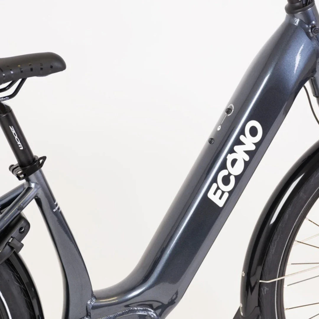 Na sliki je električno kolo znamke Econo, model Mare City. Prikazan je del okvirja kolesa, ki ima moderno obliko in je v temno sivi barvi. Na okvirju je jasno vidna oznaka znamke Econo, poleg pa so vidni tudi gumbi za upravljanje električnega sistema. Kolo je zasnovano za mestno vožnjo, kar pomeni, da je primerno za vsakodnevno uporabo v urbanem okolju.