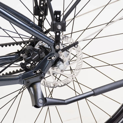 Izdelek je električno kolo, model Econo Mare City. Na sliki je prikazan zadnji del kolesa, kjer so vidni zavore in del okvirja. Oprema vključuje disk zavore, kar zagotavlja učinkovito ustavljanje, ter del mehanizma, ki omogoča gladko delovanje. Barva okvirja je temna, kar daje kolesu sodoben videz.