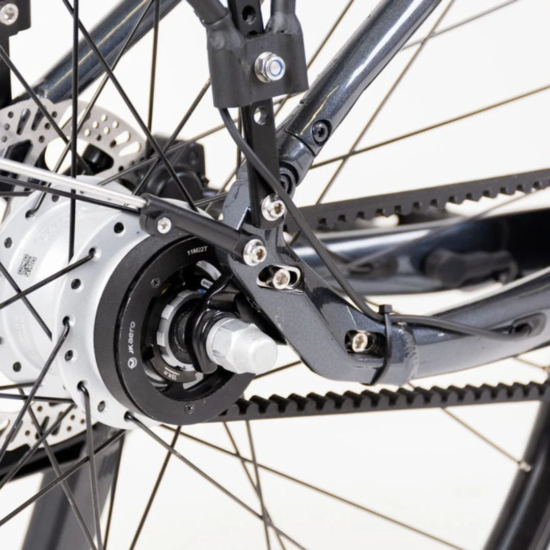 Izdelek na sliki je električno kolo, model Econo Mare City. Na sliki je prikazan del zadnjega kolesa, kjer je vidna električna motorna enota, ki je integrirana v hub kolesa. Vidni so tudi deli okvirja in zavore, kar nakazuje na robustno zasnovo, primerne za mestno vožnjo.