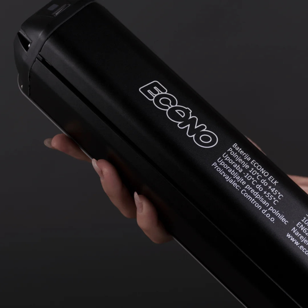 Posnetek od blizu roke, ki drži baterijo električnega kolesa Econo Pantera C6 120.