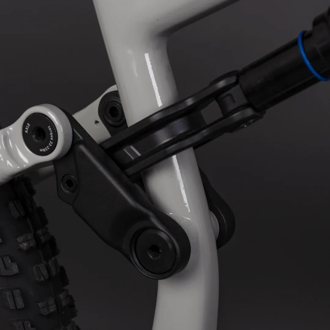 Izdelek je električno kolo, model Econo Pantera C6 120. Na sliki je prikazan del okvirja kolesa, kjer so vidni povezovalni elementi in amortizer. Barva okvirja je svetla, kar daje sodoben videz, medtem ko so detajli, kot so vijaki in povezave, zasnovani za trdnost in vzdržljivost.