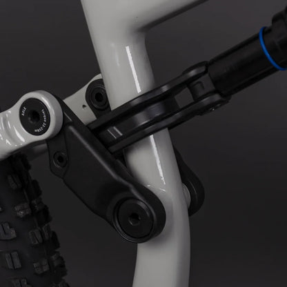 Izdelek je električno kolo, model Econo Pantera C6 120. Na sliki je prikazan del okvirja kolesa, kjer so vidni povezovalni elementi in amortizer. Barva okvirja je svetla, kar daje sodoben videz, medtem ko so detajli, kot so vijaki in povezave, zasnovani za trdnost in vzdržljivost.