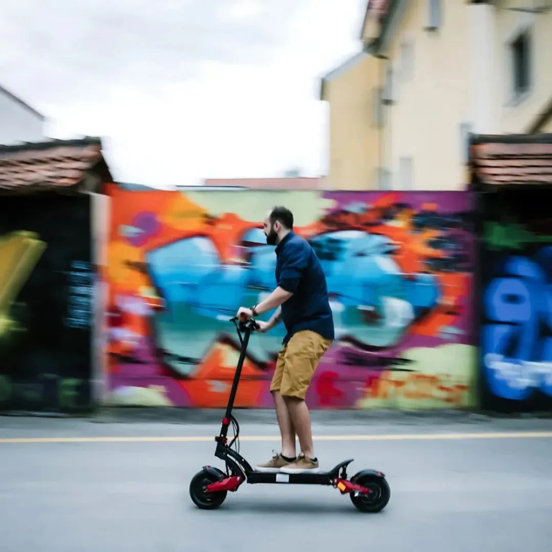 Oseba se z električnim skirojem Eco Speed 10x Pro pelje mimo pisane stene z grafiti.