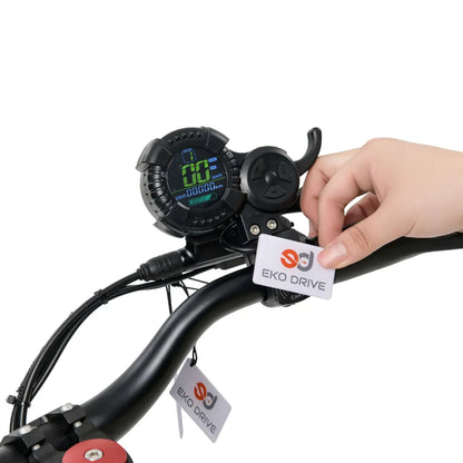 Od blizu posneto krmilo električnega skiroja z digitalnim zaslonom in roko, ki drži oznako Eko Drive