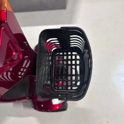 Izdelek je električni mobilni voziček, model Eco Speed Senior. Na sliki je vidna plastična košara, ki je pritrjena na voziček, kar omogoča prenašanje manjših predmetov. Voziček je v rdeči barvi, kar mu daje privlačen videz.