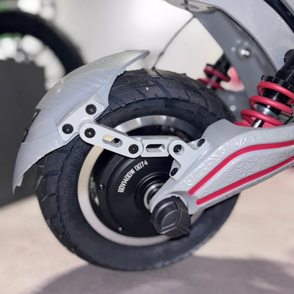 Izdelek je električni skiro, model Eco Speed 10X V2. Na sliki je vidna zadnja kolesna enota skiroja, ki vključuje motor in amortizerje. Kolo ima robustno pnevmatiko, zaščitni blatnik in posebne detajle na okvirju, kar nakazuje na kakovostno izdelavo in zmogljivost.