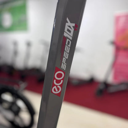 Izdelek na sliki je električni skiro, model Eco Speed 10X V2. Na sliki je vidna oznaka znamke in modela, ki je nameščena na okvirju skiroja. V ozadju so vidni drugi električni skiroji, kar nakazuje, da gre za prodajno ali razstavno okolje.