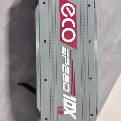 Izdelek na sliki je električni skiro, model Eco Speed 10X V2. Na sliki je vidna zgornja stran skiroja, ki ima jasno označeno ime znamke "Eco" ter model "Speed 10X V2" v belih in rdečih črkah. Površina je strukturirana, kar kaže na funkcionalno zasnovo.