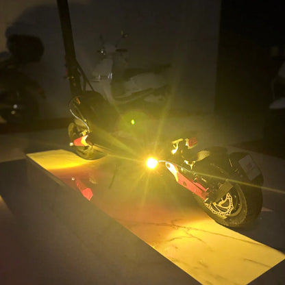 Izdelek na sliki je električni skiro, model Eco Speed 9X. Na sliki je vidna zadnja stran skiroja, ki ima vgrajeno luč, kar nakazuje na njegovo uporabo v slabših svetlobnih pogojih. Sklepamo, da je skiro zasnovan za udobno in varno vožnjo. Ozadje je temno, kar dodatno poudari svetlobo, ki jo oddaja skiro.