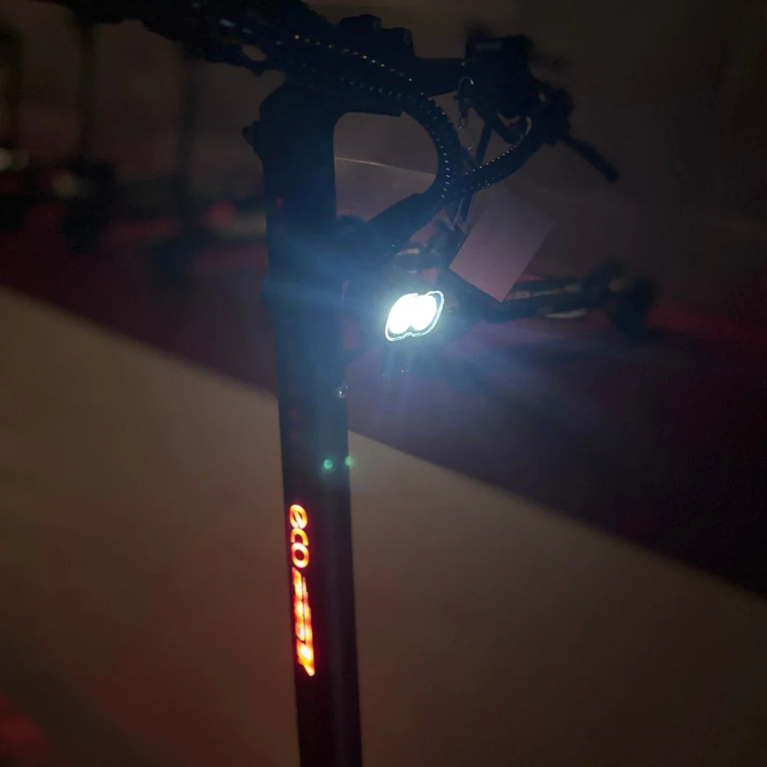 Izdelek na sliki je električni skiro, model Eco Speed 9X. Na sliki je vidna ročica skiroja z vgrajeno lučko, ki sveti, kar omogoča vožnjo tudi v slabših svetlobnih pogojih. Vidna je tudi oznaka znamke "eco" na telesu skiroja.