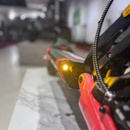 Izdelek na sliki je električni skiro, model Eco Speed 9X. Na sliki je vidna del skiroja s svetlom, ki je nameščen na sprednjem delu. Barvna kombinacija vključuje črno in rdečo, kar daje skiroju športen videz. Ozadje je zamegljeno, kar poudari detajle skiroja.