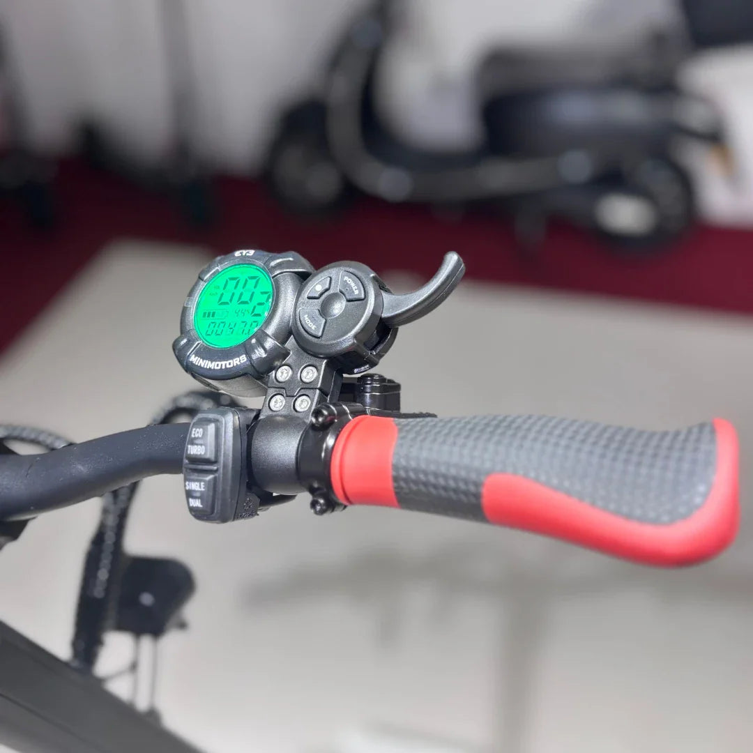 Izdelek je električni skiro, model Eco Speed 9X. Na sliki je prikazan del krmila z digitalnim zaslonom, ki prikazuje hitrost in druge podatke. Vidni so tudi gumbi za upravljanje, vključno z nastavitvami za različne načine vožnje, ter ročaj z rdečim poudarkom. V ozadju je del drugega električnega skiroja.