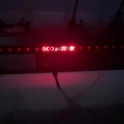 Na sliki je električni skiro model "Eco Speed 9X". Vidna je osvetlitev z rdečim napisom "ECO SPEED 9X", ki se nahaja na zadnjem delu skiroja. Osvetlitev daje skiroju sodoben videz in povečuje njegovo vidnost v temi. Na sliki je tudi del površine, ki je verjetno iz materiala, ki omogoča dobro oprijemljivost.