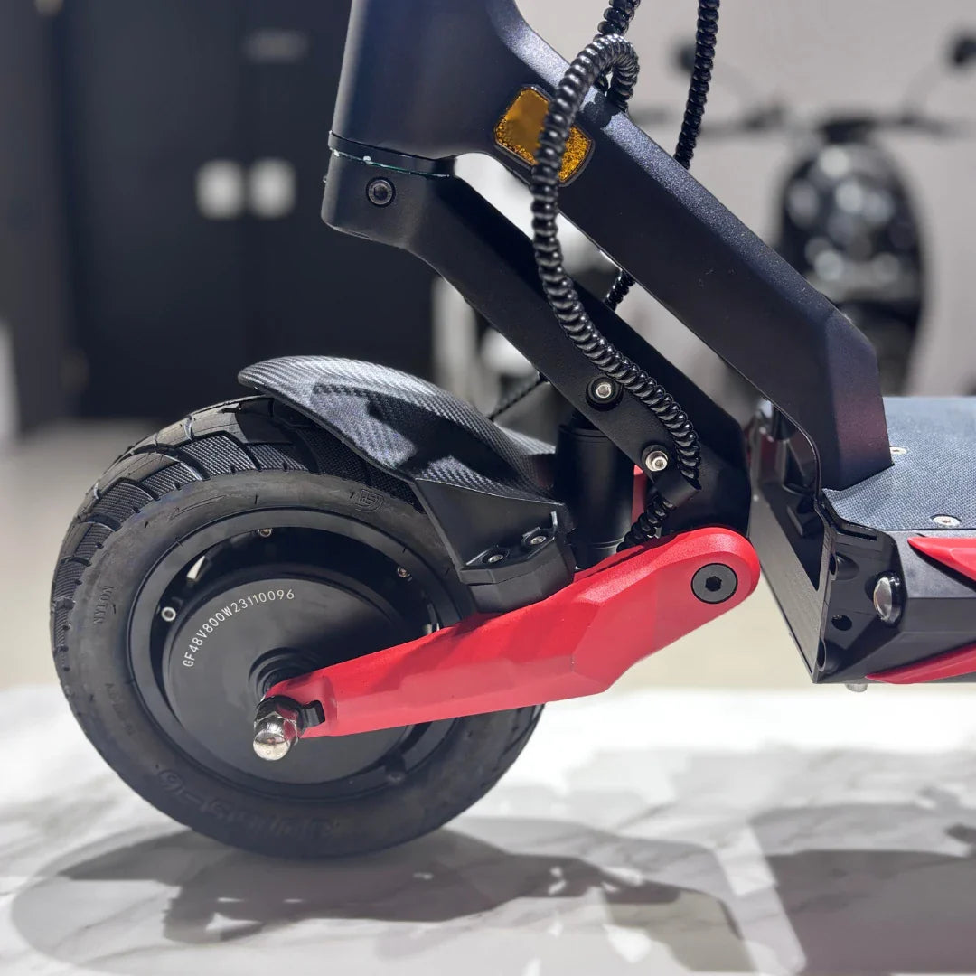 Izdelek na sliki je električni skiro, model Eco Speed 9X. Na sliki je prikazan zadnji del skiroja, kjer je vidna zadnja pnevmatika s profilom, ki omogoča boljšo oprijemljivost, ter rdeči del okvirja, ki povečuje stabilnost. Opremljen je tudi z zaščito nad kolesom in kabli, kar nakazuje na sodobno zasnovo in funkcionalnost.