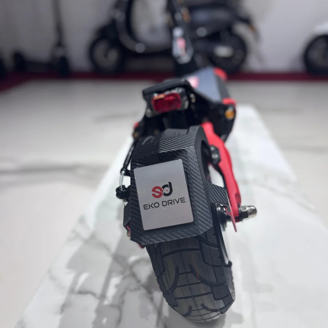 Izdelek na sliki je električni skiro, model "Eco Speed 9", znamke Eko Drive. Na sliki je prikazan zadnji del skiroja, kjer je vidna guma z izrazitim profilom ter oznaka znamke. Skuter ima športen videz in je zasnovan za udobno vožnjo. V ozadju so vidni tudi drugi električni skiroji.