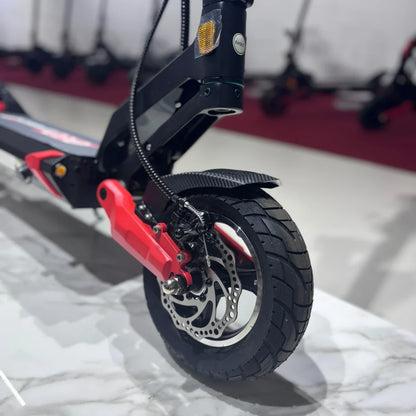 Izdelek je električni skiro, model Eco Speed 9. Na sliki je prikazan del skiroja, vključno z zadnjim kolesom, ki ima disk zavore in robustno pnevmatiko. Vidna je tudi rdeča komponenta, ki je del okvirja, ter del prednje vilice, kar nakazuje na športno zasnovo in stabilnost skiroja.