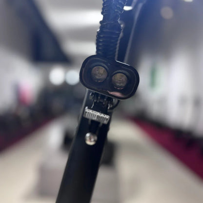 Izdelek na sliki je električni skiro, model Eco Speed 9. Na sliki je vidna sprednja luč skiroja, ki je zasnovana za boljšo vidljivost in varnost med vožnjo. Ozadje je nejasno, vendar se zdi, da je prostor, kjer so razstavljeni različni skiroji.