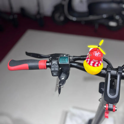 Izdelek je električni skiro model Eco Speed 9. Na sliki so vidni ročaji skiroja z rdečimi detajli, zaslon, ki prikazuje hitrost, ter kontrolne tipke za upravljanje. Na ročaju je pritrjen tudi okrasni predmet v obliki rumene račke s propelerjem. V ozadju so vidni tudi drugi električni skiroji.