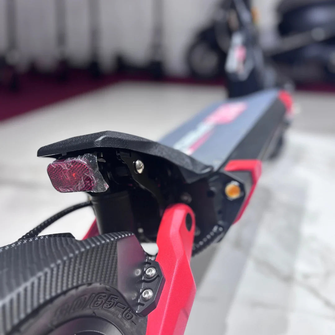 Izdelek na sliki je električni skiro, model Eco Speed 9. Vidna je zadnja stran skiroja, kjer je nameščen odsevnik in del kolesa. Barvna kombinacija vključuje črno in rdečo, kar daje skiroju dinamičen videz. Na sliki so tudi detajli konstrukcije, kar nakazuje na robustno zasnovo.