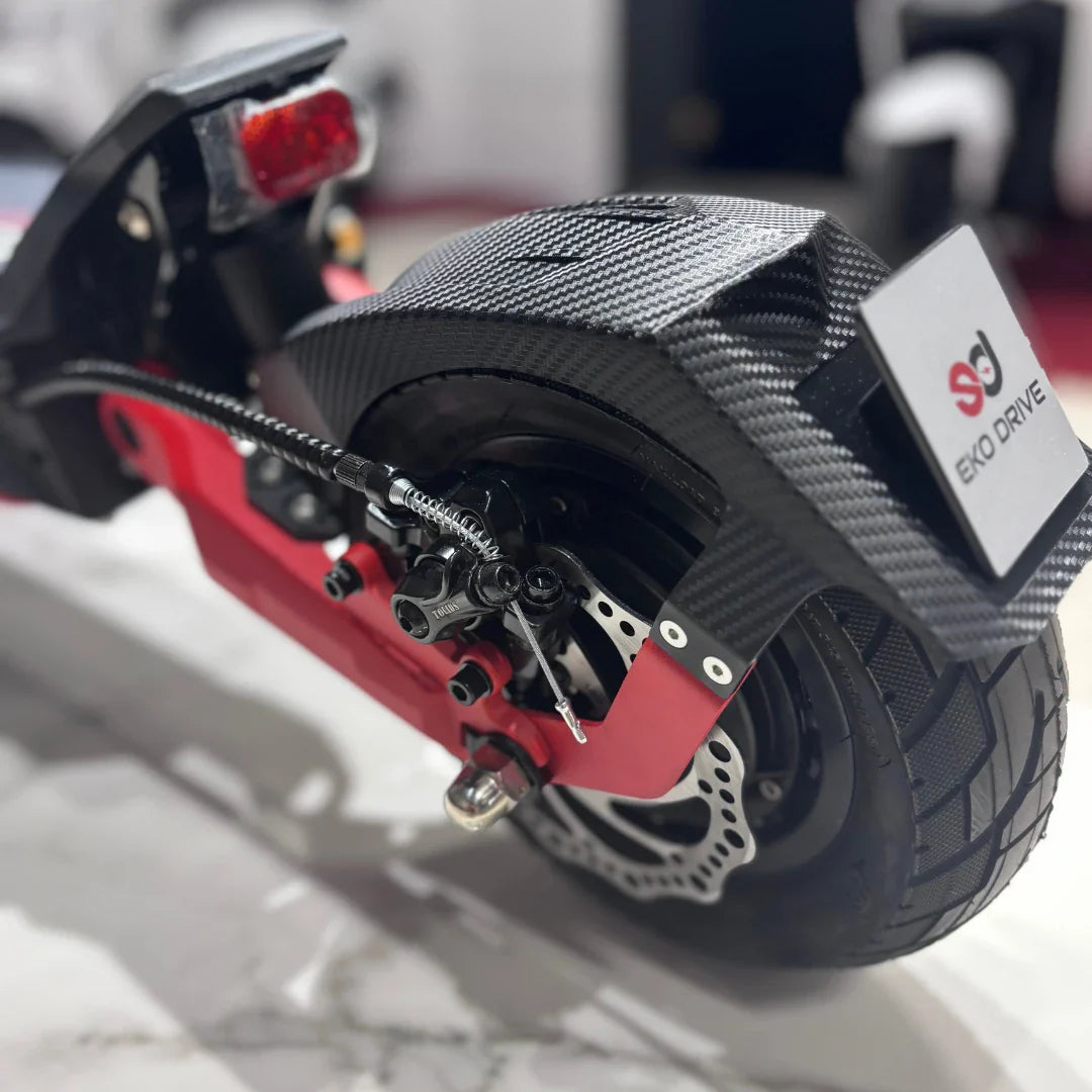 Na sliki je električni skiro model "Eco Speed 9" znamke EKO DRIVE. Vidna je zadnja kolesna enota skiroja, ki vključuje disk zavore in gumijasto pnevmatiko. Ohišje je delno izdelano iz karbonskih vlaken, kar daje skiroju sodoben in športen videz. Na zadnjem delu je tudi svetilka, ki povečuje varnost pri vožnji v temi.