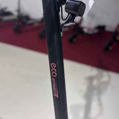 Na sliki je električni skiro model Eco Speed 9. Vidna je črna konstrukcija skiroja, na kateri je jasno označena znamka "eco" in model "speed 9". V ozadju so vidni tudi drugi električni skiroji, kar nakazuje, da gre za prodajni prostor.