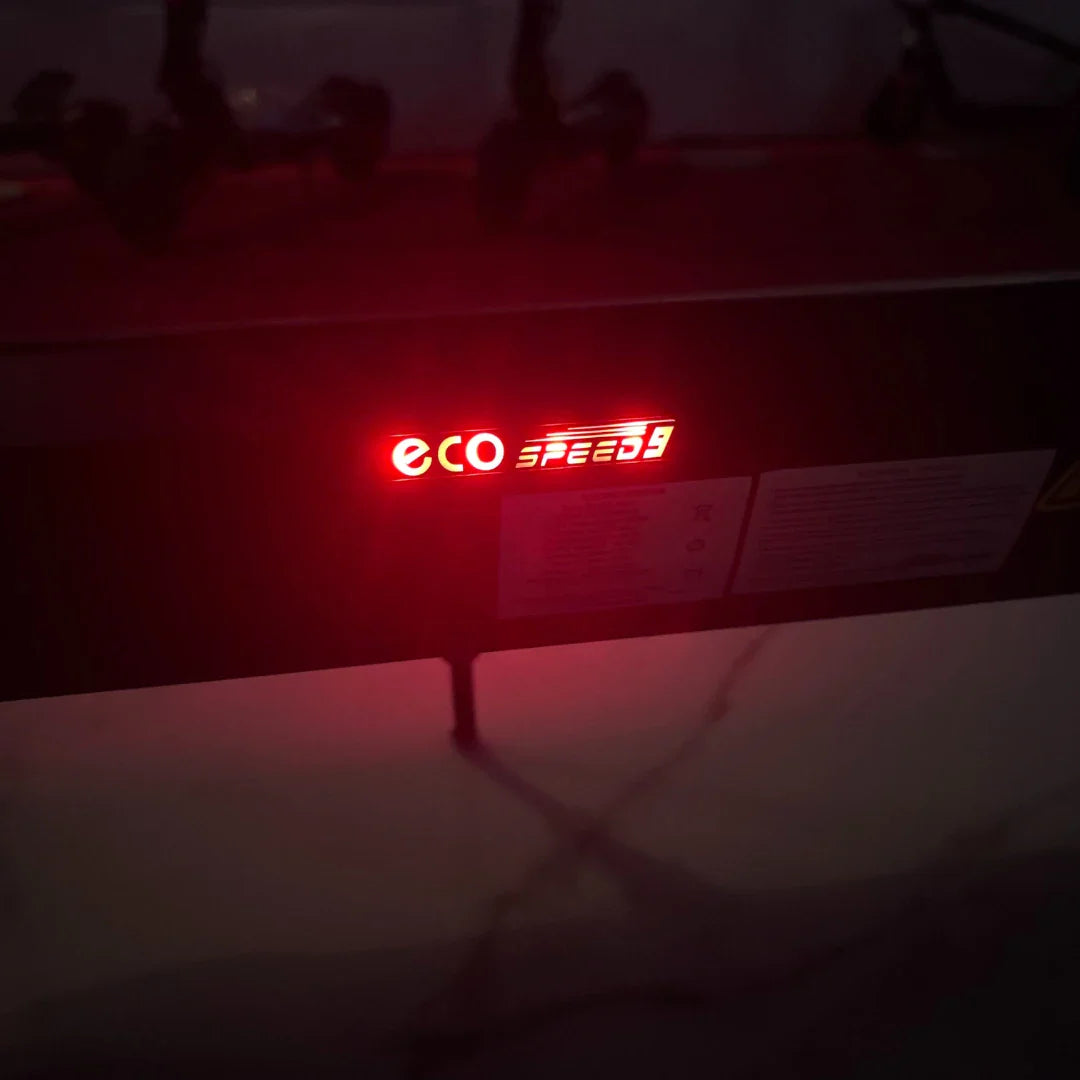 Izdelek je električni skiro, model Eco Speed 9. Na sliki je vidna rdeča LED osvetlitev, ki prikazuje ime modela "eco SPEED 9". Osvetlitev je nameščena na okvirju skiroja, kar nakazuje na funkcionalnost in moderni dizajn.