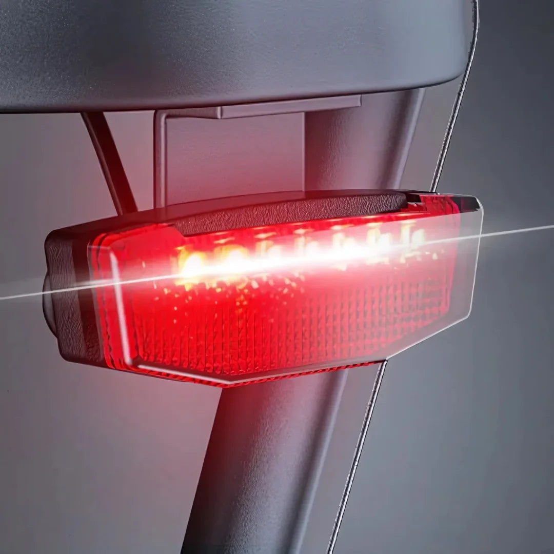 Izdelek je električno kolo, model Engwe LE20. Na sliki je prikazan zadnji svetlobni signal, ki je rdeče barve in se nahaja na zadnjem delu kolesa. Svetilka je zasnovana za povečanje vidnosti in varnosti med vožnjo v temi ali slabših svetlobnih pogojih.