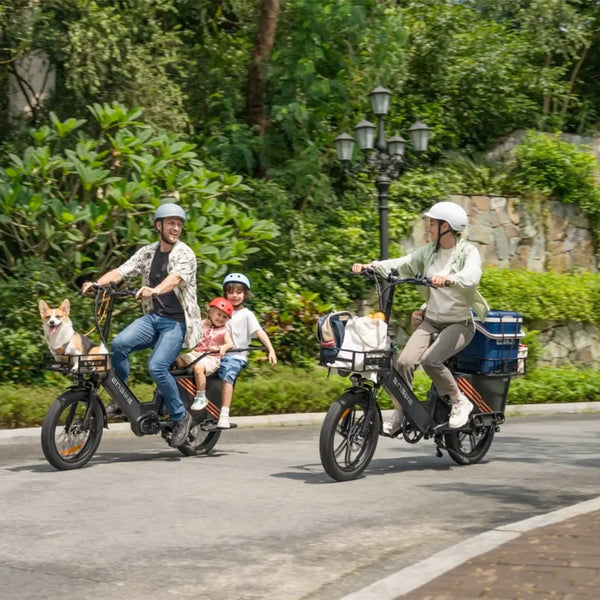 Na sliki je prikazano električno kolo znamke Engwe, model LE20. Kolo je zasnovano za družinsko uporabo, saj se na njem vozita odrasla oseba in otrok, medtem ko je ob njih tudi pes. Kolesa so opremljena s košarami za prevoz stvari, kar kaže na praktičnost in udobje pri vožnji. Ozadje je zeleno in naravno, kar ustvarja prijetno vzdušje za kolesarjenje.